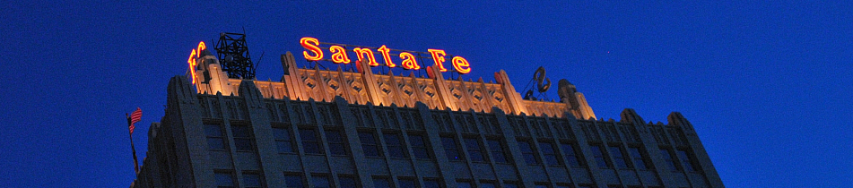 A photo of the Santa Fe building in Amarillo TX at night with the Santa Fe sign lit in red.